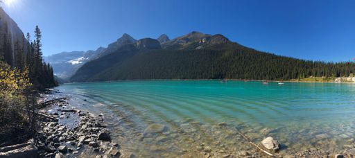 A scenic landscape of a mountain near a lake on a sunny day