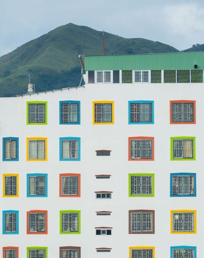 A white building with vibrant colored windows against a clear blue sky in Da Lat, Vietnam