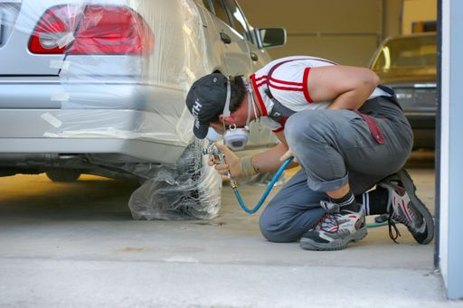 An experienced mechanic fixing a car in a residential garage