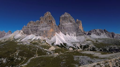 A stunning view of tall, majestic mountains on an idyllic day with a clear blue sky