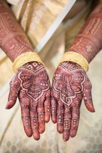 Bride's hands showing henna (mehndi) tattoos at Hindu wedding