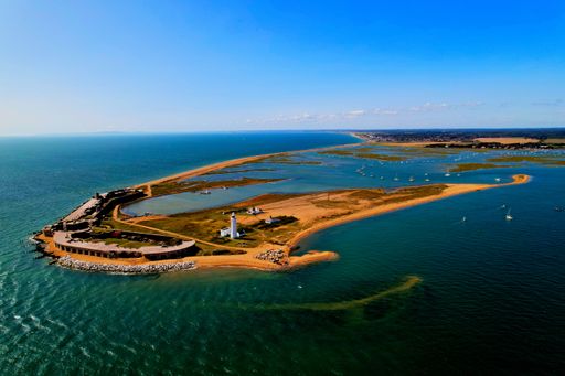 An aerial view of an idyllic tropical island with blue waters in Hurst Spit, UK
