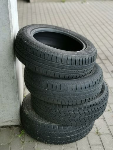 A vertical shot of a stack of used winter tires put outside the shop