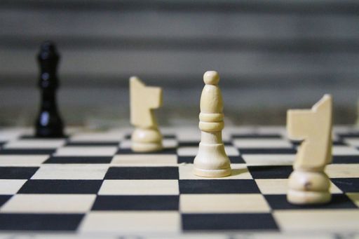 A closeup shot of a chessboard with the focus on a white's queen