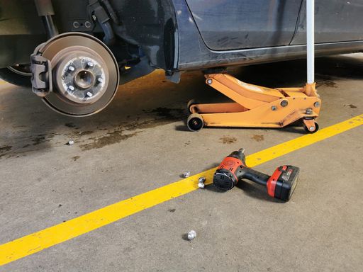 Replacing car tyre at auto mechanics shop.