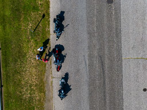 A top view of people standing near their motorcycles in a park on Long Island, NY on a sunny day