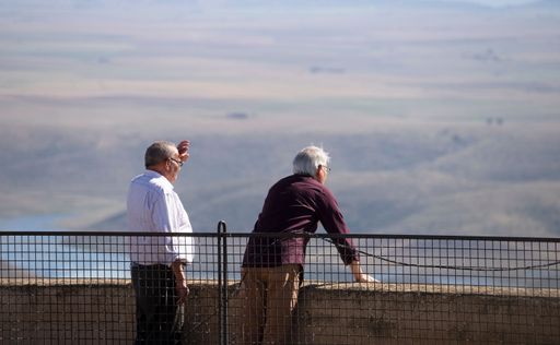 Two elderly Caucasian men talking and looking at the horizon from the castle of Puebla de Alcocer, Spain