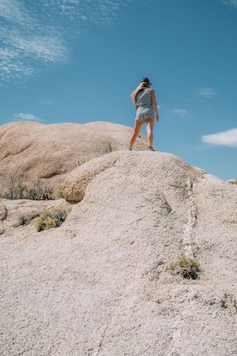 A scenic view of a female hiker on a rock at Joshua Tree National Park, California