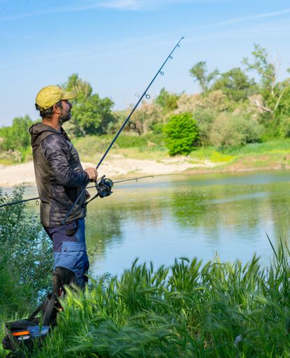 A closeup shot of a Caucasian male with beard carp fishing in the river