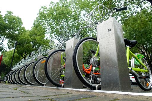 Many bikes parked on the sidewalk