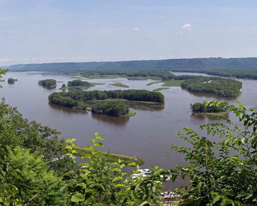 A high angle shot of a lake surrounded by beautiful greenery under a cloudy sky