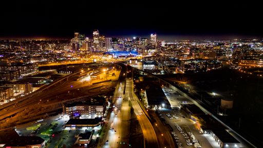 A nightscape of a city skyline illuminated with streetlights in downtown Denver, Colorado