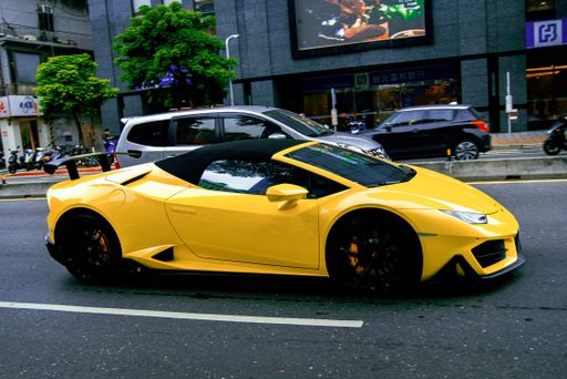 A yellow Lamborghini fast sports car driving in the streets of Taipei, Taiwan