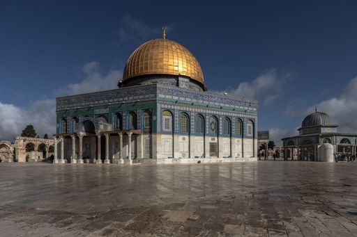 A sunny day view of the historic Dome of the Rock in Jerusalem, Israel, with its golden dome