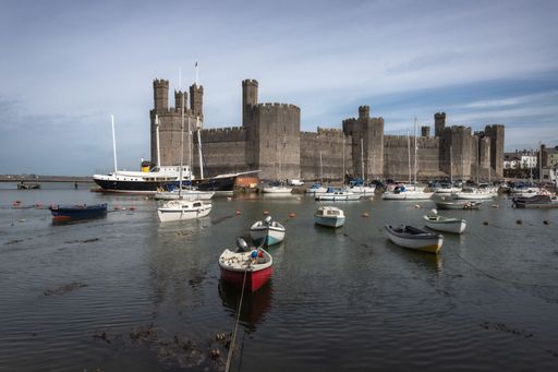 An aerial view of Caenarfon Castle in Wales, with boats in the foreground