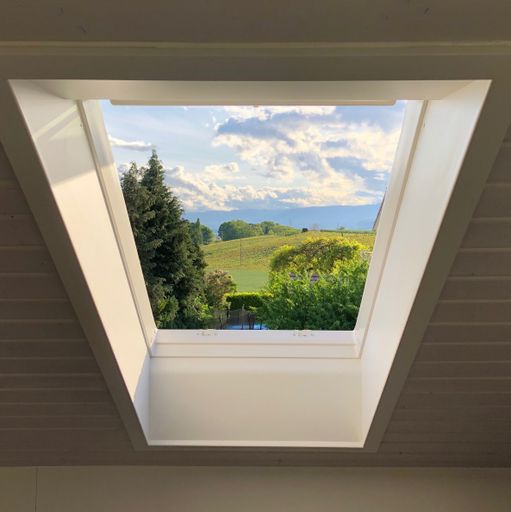 A low angle shot of a beautiful landscape seen from an attic window