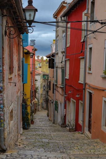 A vertical shot of a narrow alleyway with colorful houses at either side in Rovinj, Croatia