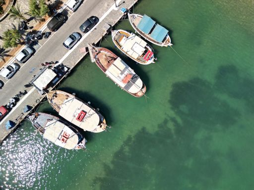 An aerial view of Elounda Bay on the Greek island of Crete with a fleet of boats parked in the harbor