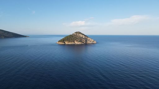 An aerial view of a island surrounded by crystal clear ocean waters