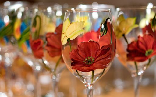 A closeup shot of painted yellow and red tulips on the wine glasses