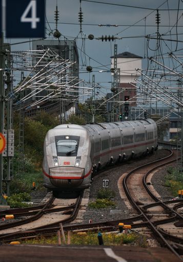 A passenger train on the tracks of a busy train station in Cologne, Germany.