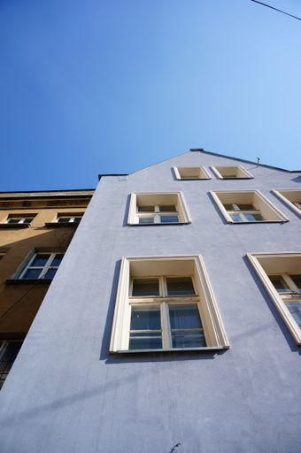 A low angle shot of a the facade of a residential building under a clear blue sky