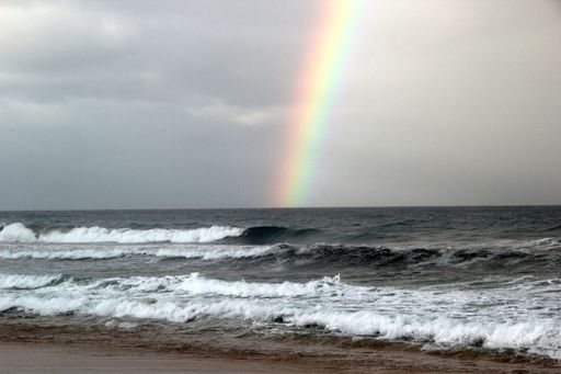 A beautiful view of rainbow on the waving ocean