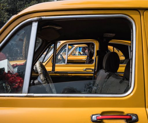 A yellow taxi cab with its interior visible looking out from the window