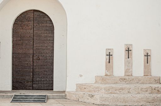 An entrance door and three crosses outside the Church of Sant Francesc Xavier in, Spain