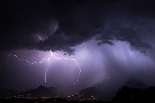 Landscape view of a thunderstorm with lightning bolts over a mountain range in the region of Montreux Switzerland