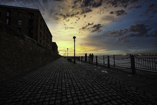 A beautiful view of the people fishing in the Royal Albert Dock Promenade in Liverpool, UK at dawn