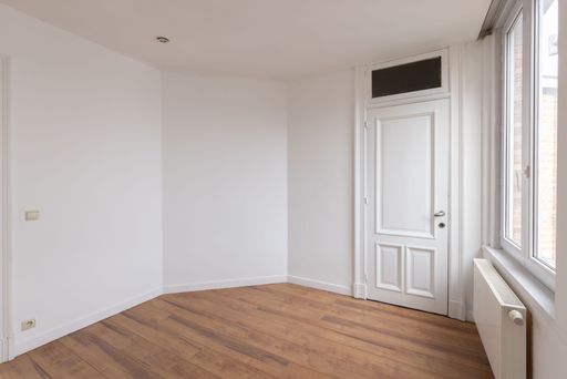 A view of a spacious and unoccupied room, taken from the side doorway