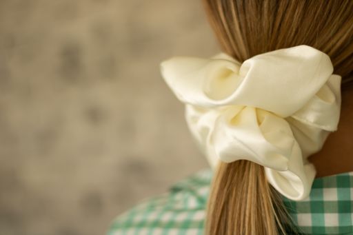 A shallow focus of long dirty blonde hair tied with a scrunchie