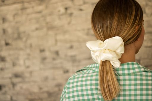 A shallow focus of long dirty blonde hair tied with a scrunchie