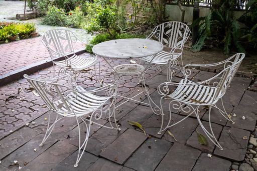 A white round table with chairsin a backyard