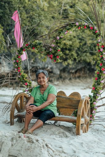 A Beautiful Portrait of a Gorgeous Asian Filipino Grandmother sitting on a Bench while on a Holiday Summer Vacation in the Philippines
