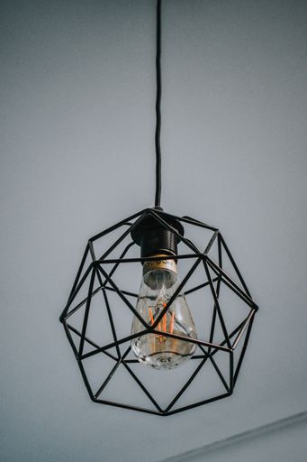 A vertical shot of minimalist chandelier hanging on the ceiling