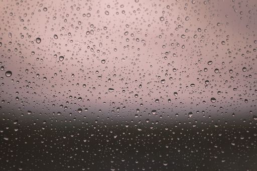 A closeup shot of a glass surface covered in waterdrops