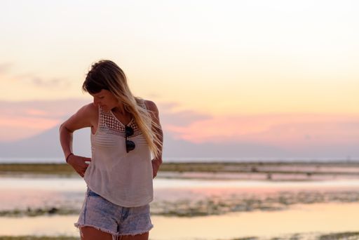 A beautiful young blonde girl on Gili Trawangan beach in Lombok, Indonesia at sunset time