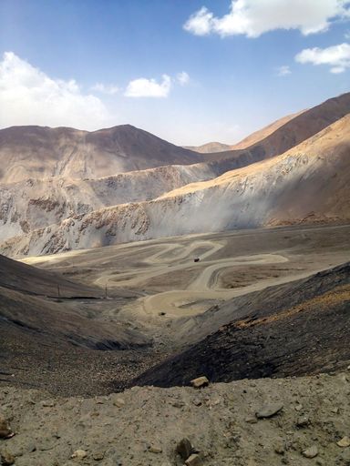 Panoramic view of a picturesque valley landscape with a winding road snaking through it, leading to the distant horizon
