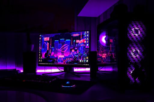 Photo of pc setup that is shining with purple color.