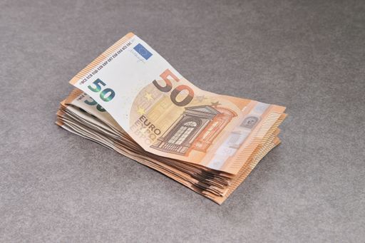 A closeup of a stack of cash fifty Euro bills on the table