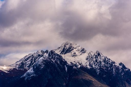 A beautiful shot of a snowy peak in Bariloche, Argentina under a purple-white cloudy sky