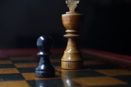 A selective focus shot of two wooden chess pawns on a checkered board
