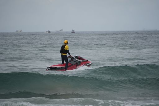 A man on a personal watercraft in the middle of a pristine ocean on a cloudy day