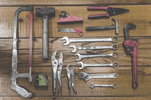 A display of hand tools on a wooden workbench