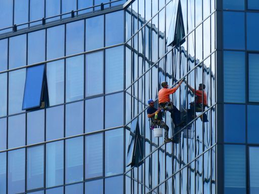 Novi Sad,Serbia - May 12th 2021 : Two workers cleaning the glass building's windows