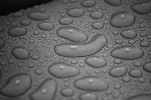 A closeup shot of water drops on a grey surface - perfect for backgrounds