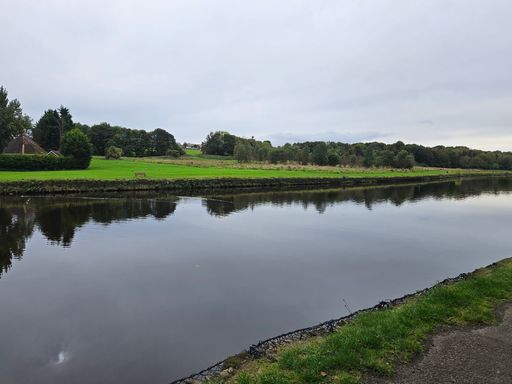 A scenic shot of a river winding its way through a lush green landscape