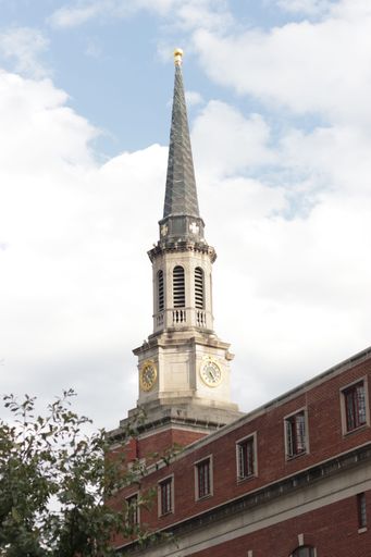 A vertical shot of a beautiful clock tower against the cloudy daytime sky